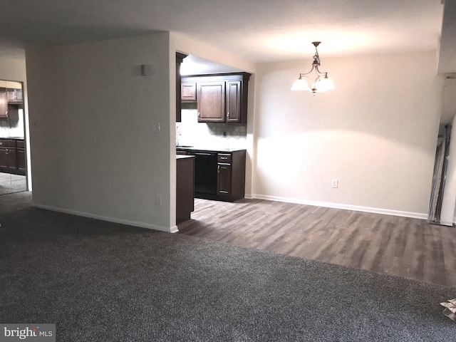 unfurnished living room featuring sink, dark hardwood / wood-style flooring, and a chandelier