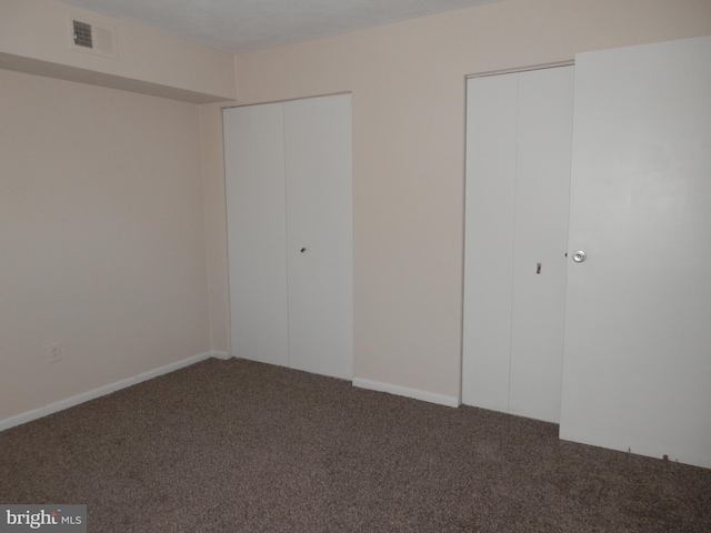 unfurnished bedroom with dark carpet