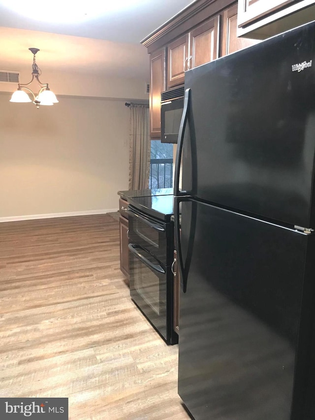 12 Dougherty Blvd Unit A5, Glen Mills, PA 19342 - kitchen with black appliances, visible vents, an inviting chandelier, light wood-style flooring, and baseboards