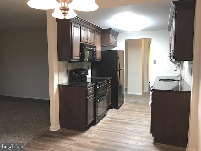 kitchen featuring tasteful backsplash, black appliances, sink, light hardwood / wood-style floors, and dark brown cabinetry