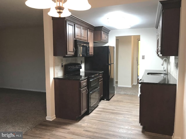 12 Dougherty Blvd Unit A5, Glen Mills, PA 19342 - kitchen featuring dark brown cabinets, a sink, baseboards, black appliances, and light wood-style floors