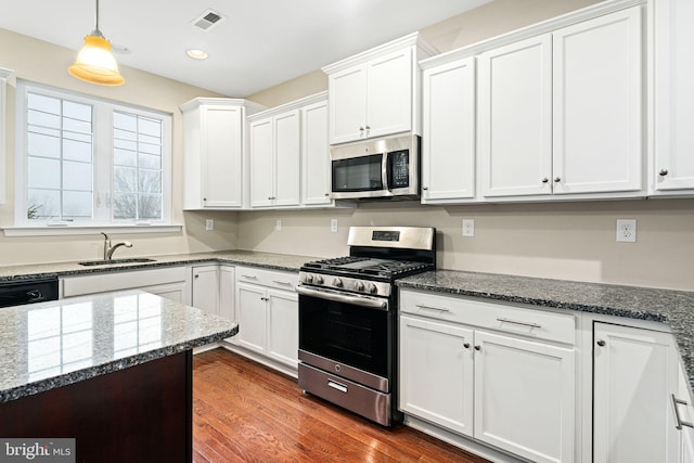 kitchen with white cabinetry, sink, dark hardwood / wood-style floors, stone countertops, and appliances with stainless steel finishes