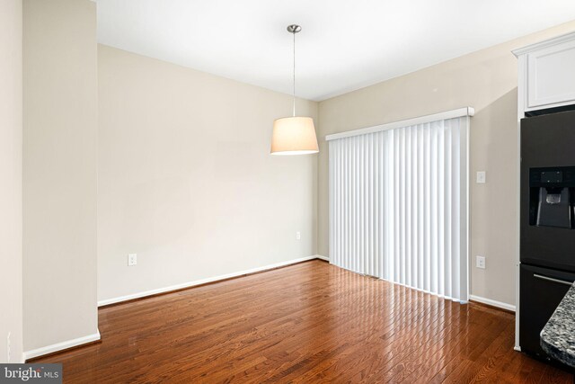 unfurnished dining area with dark wood-type flooring