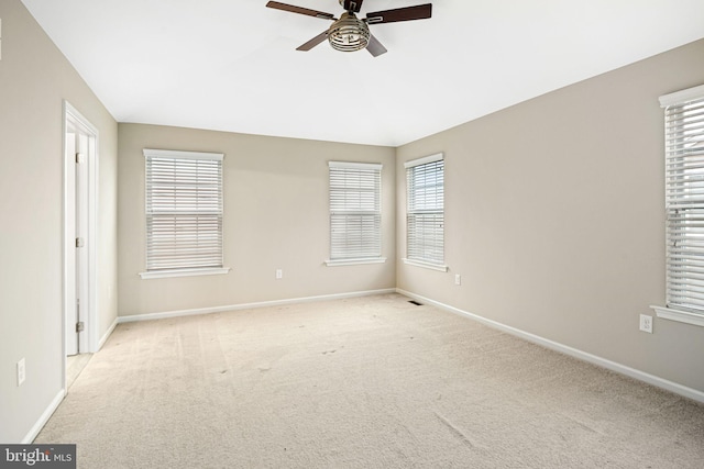 carpeted spare room featuring ceiling fan