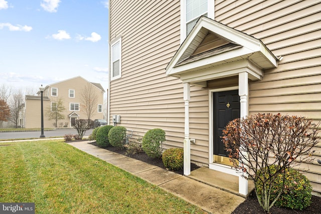 view of exterior entry featuring a lawn