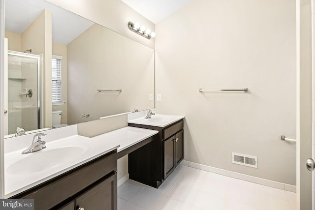 bathroom featuring tile patterned floors, a shower with door, vanity, and toilet