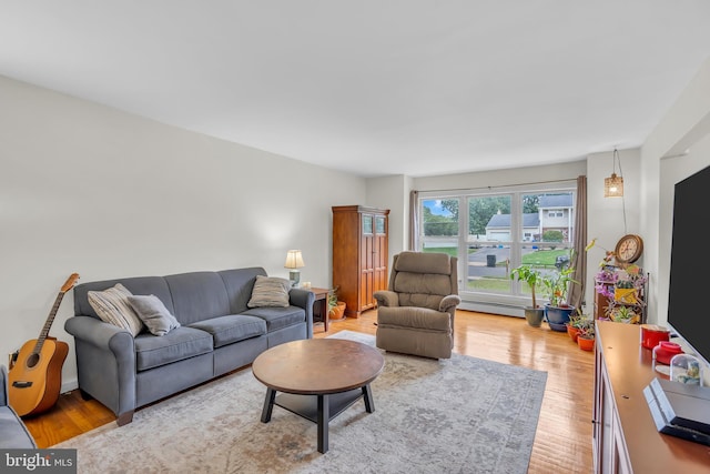 living room with a baseboard heating unit and light wood-type flooring