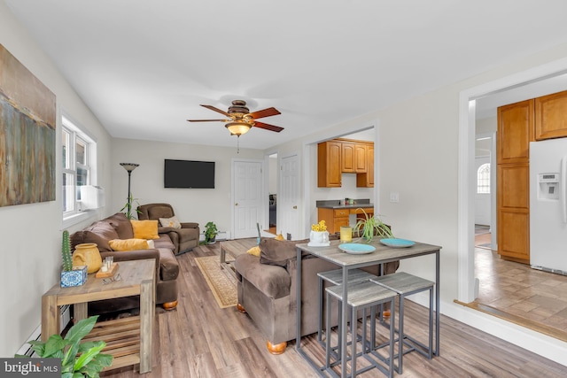 living room with ceiling fan, light wood-type flooring, and a wealth of natural light