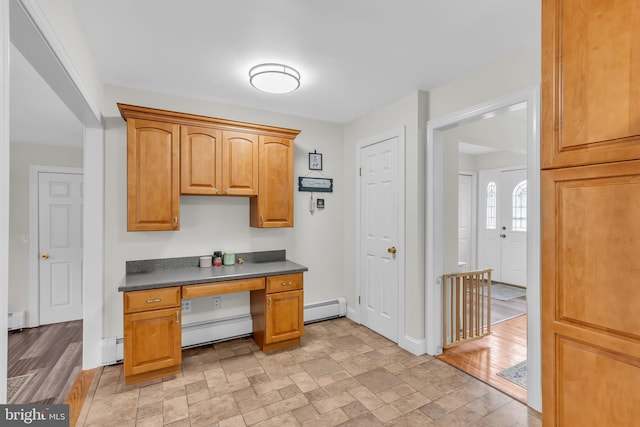 kitchen featuring baseboard heating, light hardwood / wood-style flooring, and built in desk