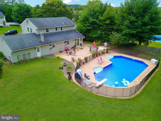 view of pool with a diving board, a patio area, and a lawn