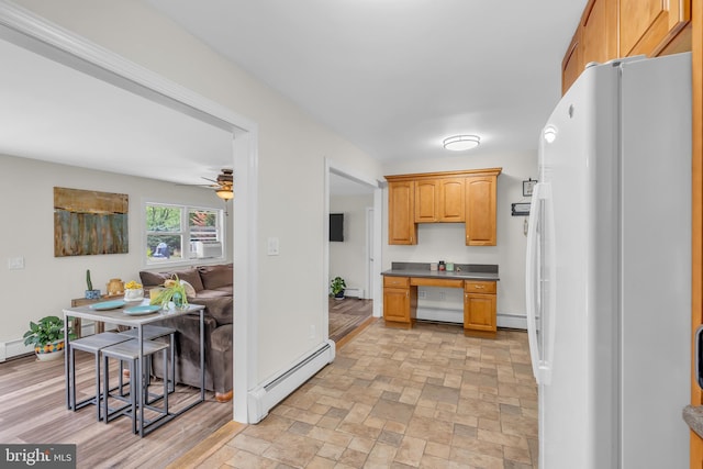 kitchen featuring white fridge, ceiling fan, a baseboard heating unit, and light hardwood / wood-style floors