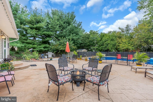 view of patio / terrace featuring area for grilling, an outdoor fire pit, and a fenced in pool