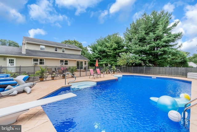 view of swimming pool featuring a patio and a diving board