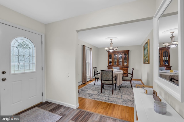 foyer entrance with an inviting chandelier and dark hardwood / wood-style flooring