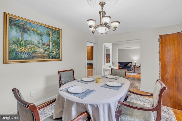 dining room with wood-type flooring and a chandelier