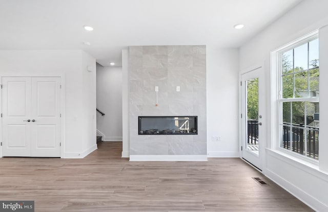 10812 Willow Ter, Fairfax, VA 22030 - unfurnished living room featuring wood finished floors, baseboards, recessed lighting, a fireplace, and stairs