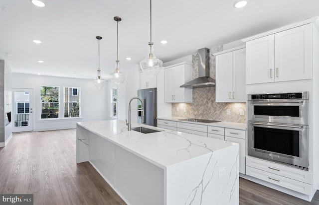 10812 Willow Ter, Fairfax, VA 22030 - kitchen with wall chimney range hood, appliances with stainless steel finishes, a sink, wood finished floors, and decorative backsplash