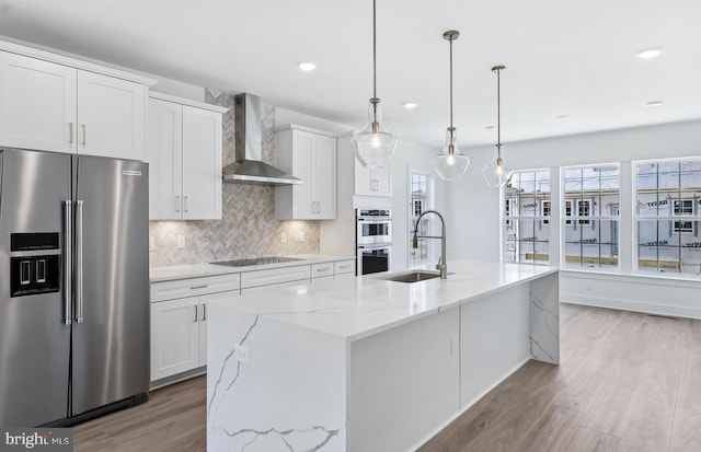 10812 Willow Ter, Fairfax, VA 22030 - kitchen with appliances with stainless steel finishes, wall chimney exhaust hood, a sink, light wood finished floors, and tasteful backsplash