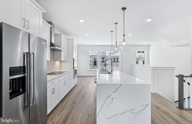 10812 Willow Ter, Fairfax, VA 22030 - kitchen featuring stainless steel appliances, a sink, wall chimney exhaust hood, light wood-style flooring, and recessed lighting
