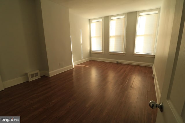 unfurnished room with dark wood-type flooring and a healthy amount of sunlight