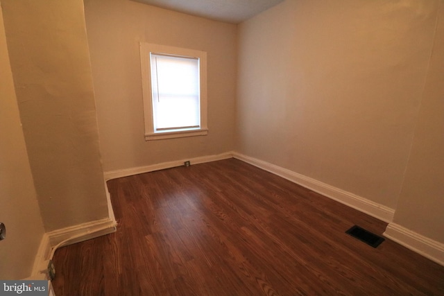 empty room with dark hardwood / wood-style flooring