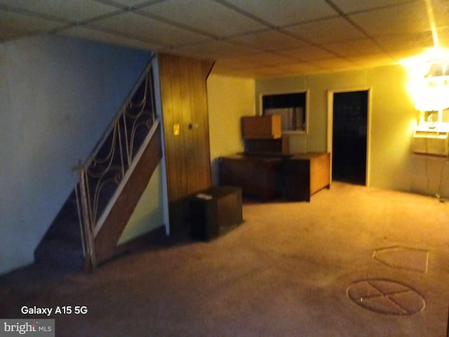 basement featuring a drop ceiling and carpet flooring