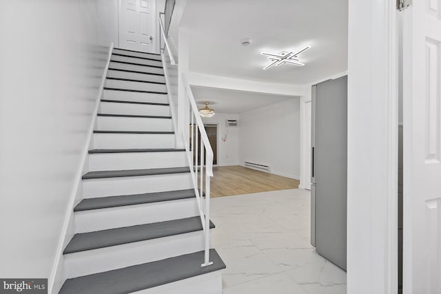 stairway with wood-type flooring and baseboard heating