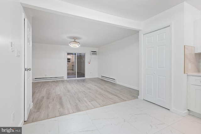 unfurnished room featuring light hardwood / wood-style flooring and a baseboard heating unit