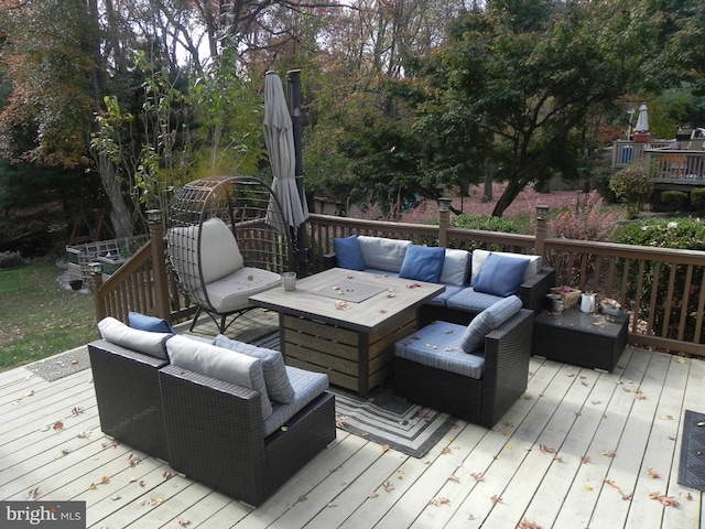 deck featuring an outdoor living space with a fire pit