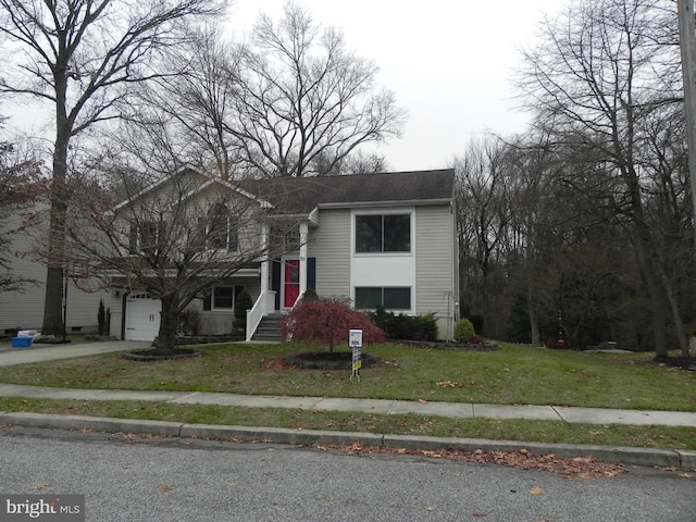 raised ranch with a garage and a front lawn