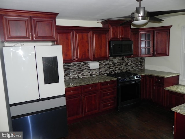 kitchen with ceiling fan, dark hardwood / wood-style flooring, dark stone countertops, decorative backsplash, and black appliances