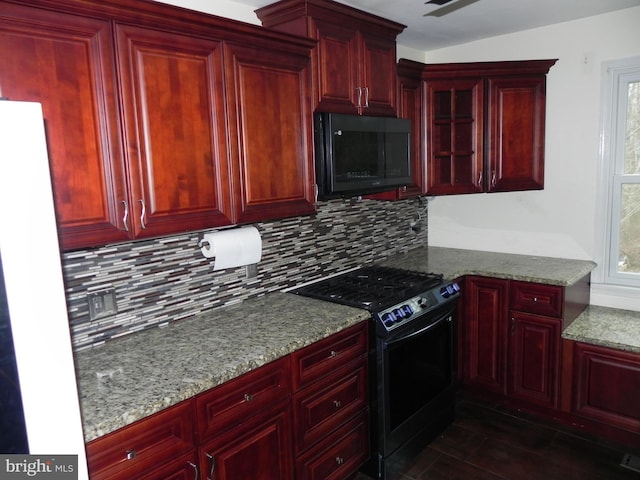 kitchen with light stone countertops, tasteful backsplash, and black appliances