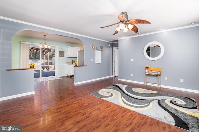 interior space featuring dark wood-type flooring, ceiling fan with notable chandelier, and ornamental molding