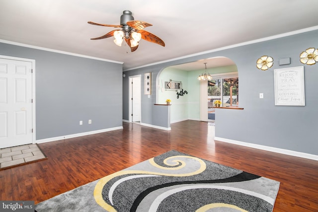 living room featuring dark wood-type flooring, ceiling fan with notable chandelier, and ornamental molding