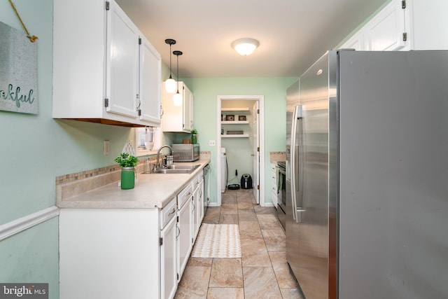 kitchen featuring white cabinetry, sink, decorative light fixtures, and appliances with stainless steel finishes