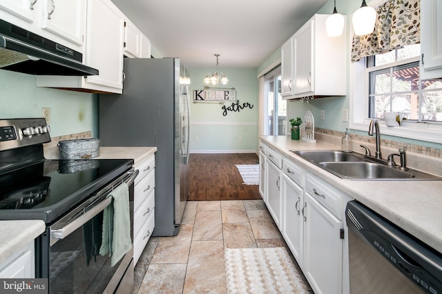 kitchen featuring pendant lighting, white cabinetry, sink, and appliances with stainless steel finishes