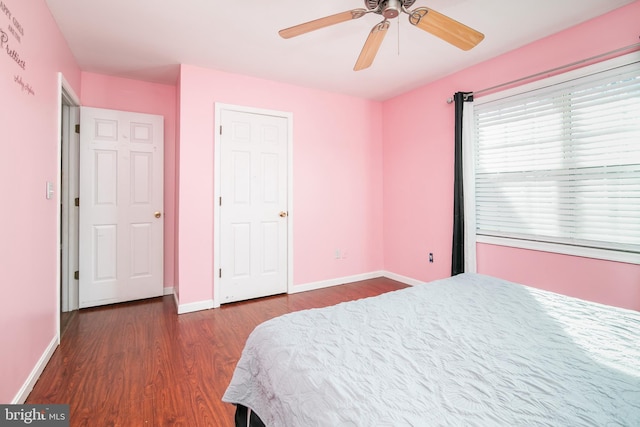 bedroom with dark hardwood / wood-style floors and ceiling fan