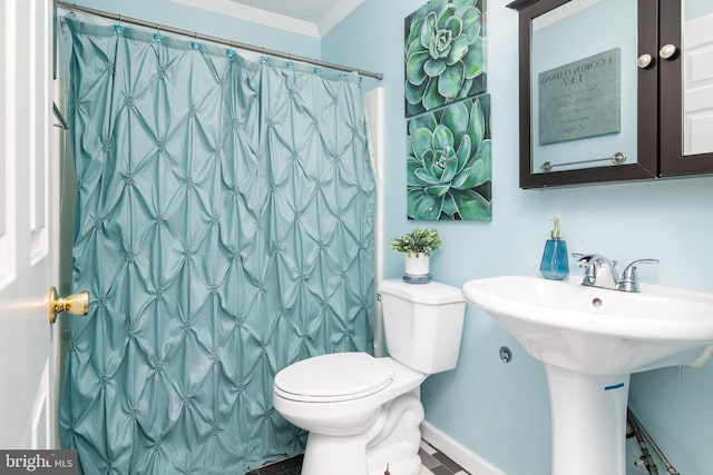 bathroom featuring a shower with shower curtain, toilet, and crown molding