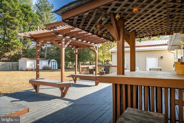 wooden terrace featuring a pergola and a shed