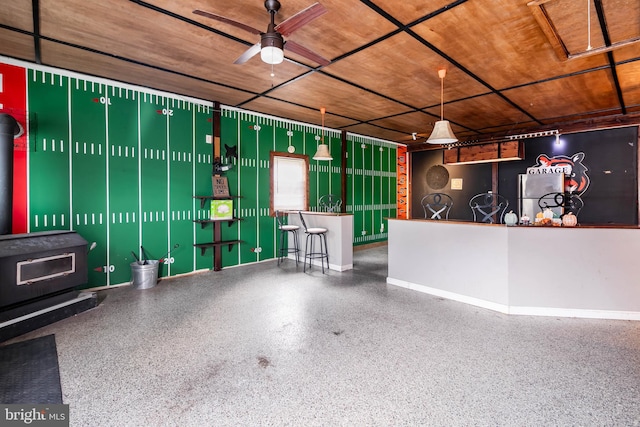 garage with ceiling fan and a wood stove