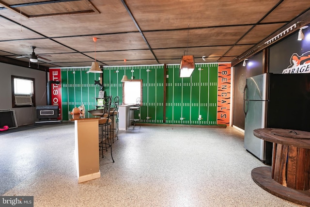 garage with stainless steel fridge and ceiling fan