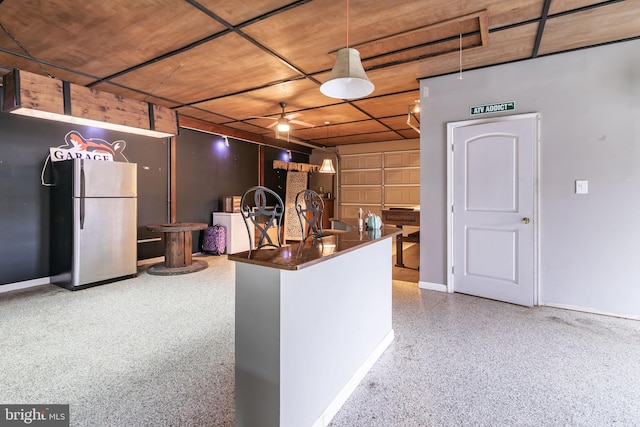 interior space featuring stainless steel refrigerator and decorative light fixtures