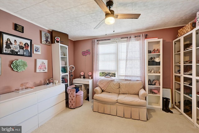 living area with carpet and ceiling fan