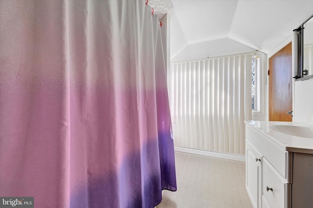 bathroom featuring vanity and lofted ceiling