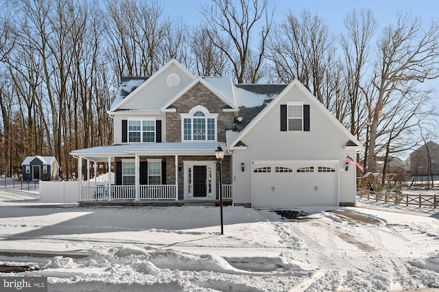 view of property with covered porch and a garage