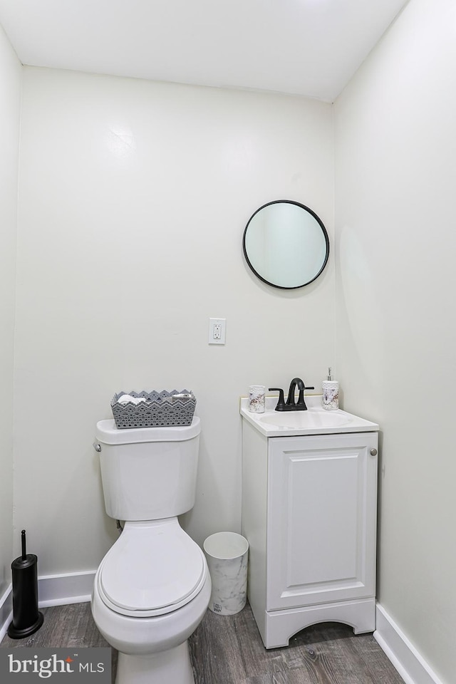 bathroom featuring vanity, hardwood / wood-style flooring, and toilet