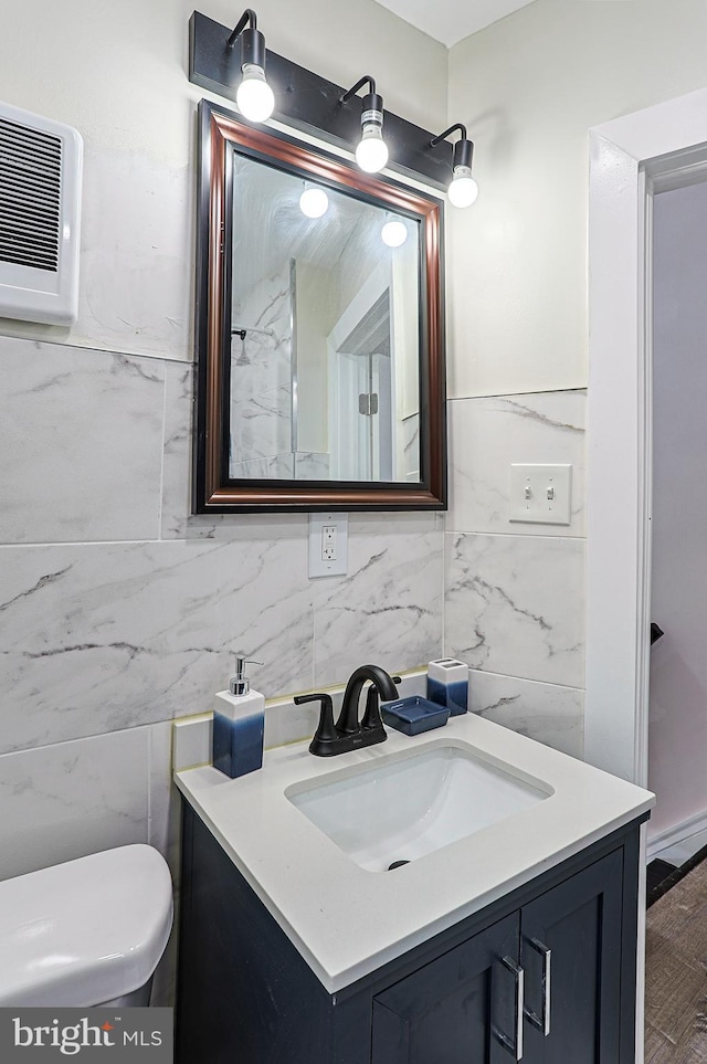 bathroom featuring tile walls, vanity, hardwood / wood-style floors, and toilet