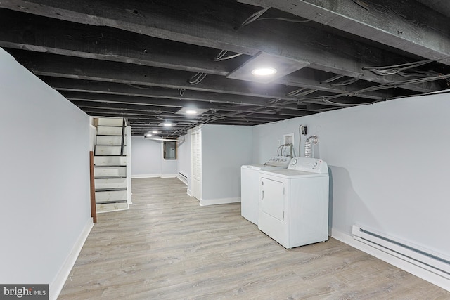 laundry room featuring light wood-type flooring, electric panel, separate washer and dryer, and a baseboard radiator