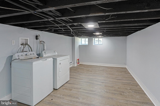 laundry area with light hardwood / wood-style floors and washer and clothes dryer