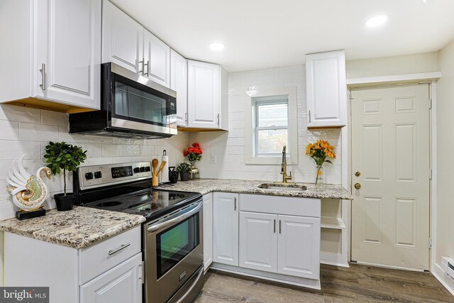 2544 N Gratz St, Philadelphia, PA 19132 - kitchen with appliances with stainless steel finishes, a sink, white cabinets, dark wood-type flooring, and light stone counters